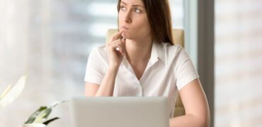 Woman,With,Pensive,Facial,Expression,Looking,Aside,While,Sitting,At